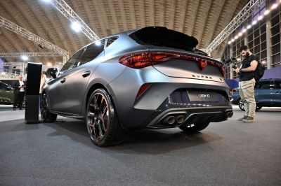 Matte gray sporty hatchback rear with quad exhaust and alloy wheels.