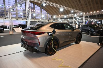 Electric SUV rear with charging plug connected in exhibition