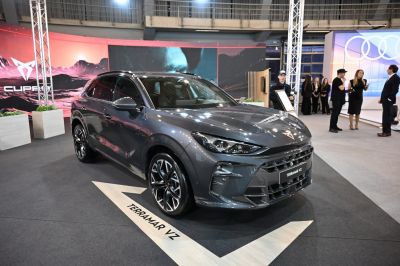 Front side view of a sporty SUV with sleek headlights and bold grille