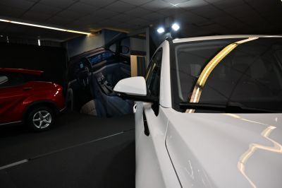 Close-up of white side mirror and front body panel with sleek contours