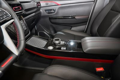 Modern car interior center console with rotary knob and red accents