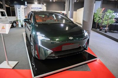 Futuristic electric sedan with sharp LED headlights and aerodynamic shape.