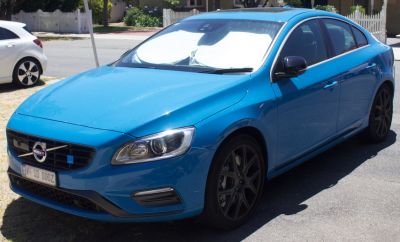 Blue sedan showing front side with headlights and alloy wheels