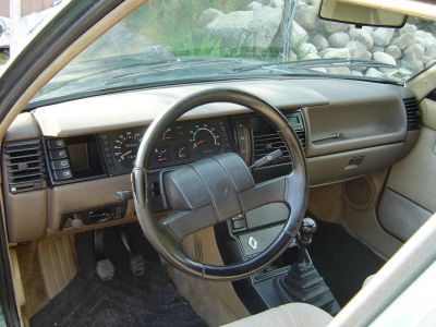 Vintage car dashboard with steering wheel and manual gear shifter.