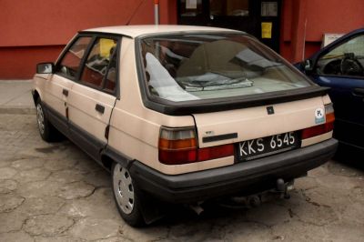 Rear view of retro compact hatchback with distinctive taillights and black bumpers