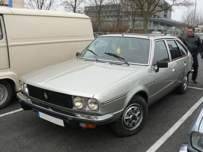 Silver hatchback with quad headlights and chrome details.