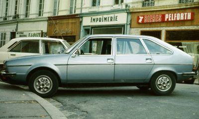 Side profile of a classic vintage sedan with hatchback and alloy wheels