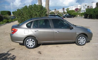 Side profile of a compact four-door sedan with silver wheel covers