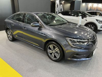 Front side view of a grey sedan with modern headlights and alloy wheels