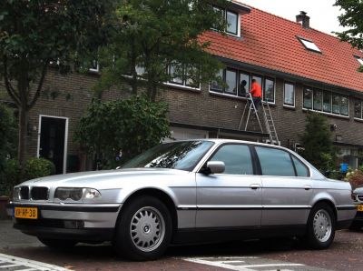 Silver long-wheelbase luxury sedan parked on urban street
