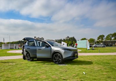 SUV with open front door and rear hatchback on grass outdoors