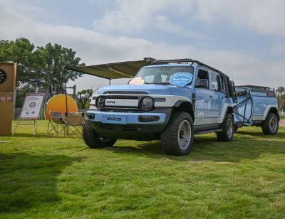 Robust off-road SUV with rugged tires and matching trailer outdoors