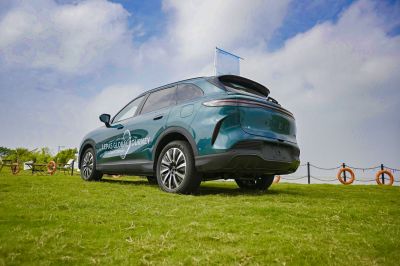 Rear side view of a sporty modern SUV with sleek rims on grass