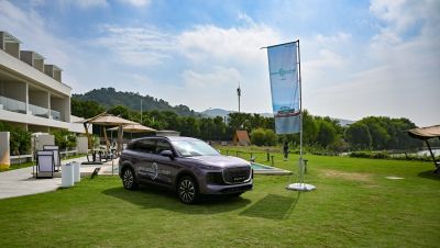 Modern SUV with distinct front grille and side profile parked on green lawn.