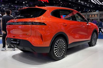 Rear and side view of a sleek red electric SUV with LED taillights and aerodynamic design.