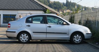 4-door sedan side profile with black trim and factory wheel covers
