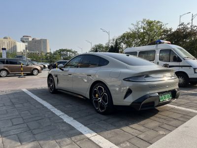 Rear side view of a sleek electric sedan with distinctive taillights and sporty wheels