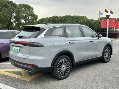 Rear side view of a sleek 2025 SUV with modern taillights and alloy wheels