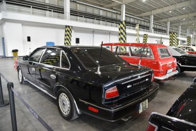 Rear and side view of a classic luxury sedan with dual antennas