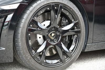 Glossy black alloy wheel with branded brake caliper and ventilated disc brake