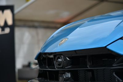 Close-up of front grille and Lamborghini emblem on blue hood