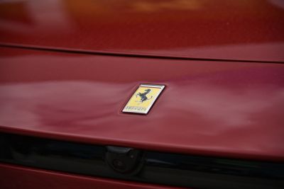 Close-up of Ferrari prancing horse emblem on red car hood