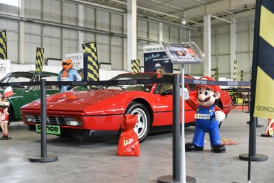 Red wedge-shaped sports coupe with pop-up headlights in an indoor exhibit
