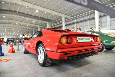 Red vintage sports car rear with round taillights and dual exhaust
