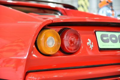 Close-up of rear light cluster and Ferrari emblem on red body.