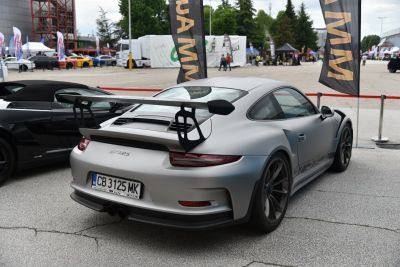 Rear of a matte silver sports coupe with large fixed rear wing