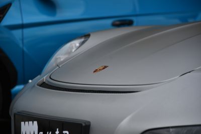Close-up of sleek front hood and headlight with emblem