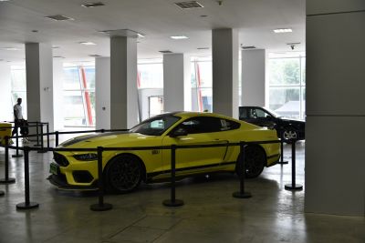 Yellow muscle coupe with black racing stripes and aggressive styling