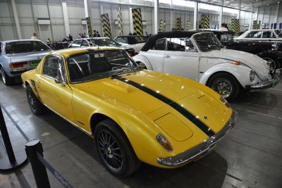 Yellow vintage sports coupe with black racing stripe and pop-up headlights.