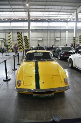 Yellow sports car with central dark racing stripe front view