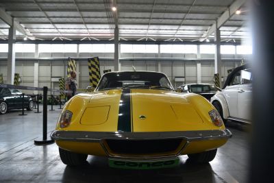 Front view of yellow classic sports car with central racing stripe