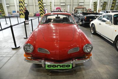 Front view of a red vintage car with oval headlights and horizontal front vents