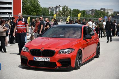 Red luxury sedan front view with black wheels and tinted windows