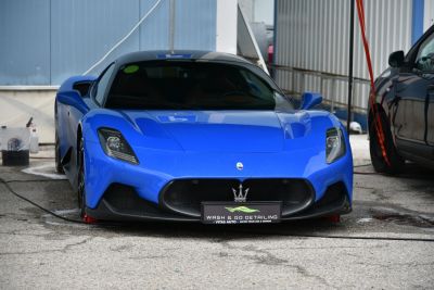Front view of a blue sports car with aggressive grille and headlights