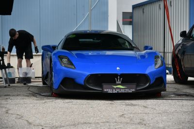 Blue sports car front view with sleek headlights and large grille