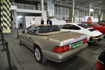Rear and side view of beige convertible with prominent tail lights and smooth body lines