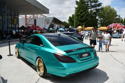 Matte green luxury coupe with gold wheels and sporty rear spoiler
