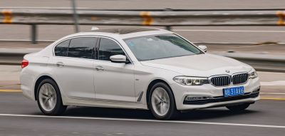 White luxury sedan side and front view in motion