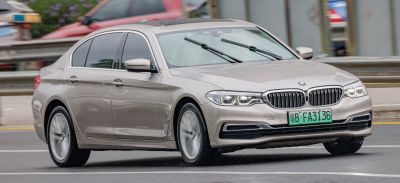 Luxury sedan front view with LED headlights and kidney grille in motion