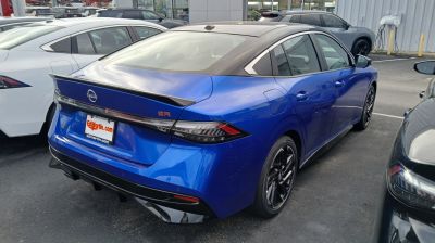 Rear and side view of blue sporty sedan with black roof and spoiler