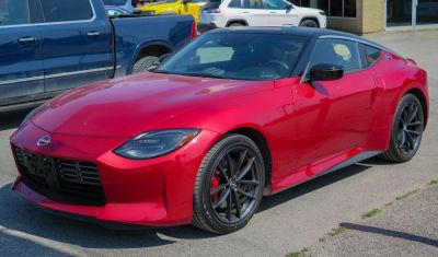 Red sport coupe front-side view with sleek headlights and black alloy wheels
