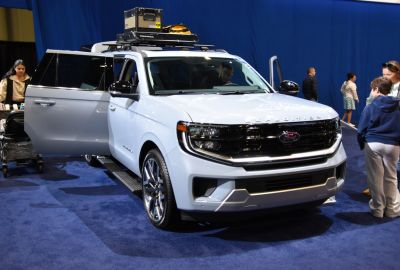 Full-size SUV with roof rack gear and open side doors