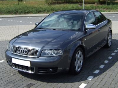 Front side view of a sedan with alloy wheels and dual round headlights