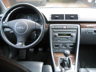 Dashboard with instrument cluster, wood trim, and manual transmission gearstick