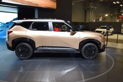 Side profile of a futuristic prototype SUV with black wheel arches and sleek multi-spoke wheels