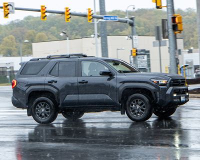 Black SUV with rugged off-road design and roof rails on wet road